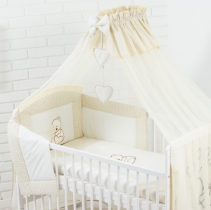 Beżowa moskitiera do łóżeczka z serduszkami.